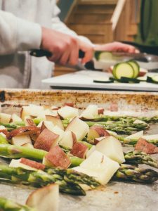 asparagus, potatoes, and bacon are being prepared in a kitchen