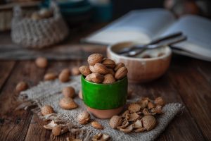 a jar of nuts and a bowl of nuts on a table